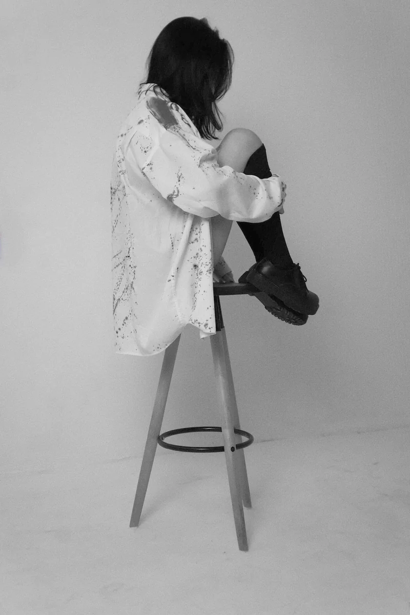 Woman seated on a three-legged stool, representing balance and the life a financial plan supports.